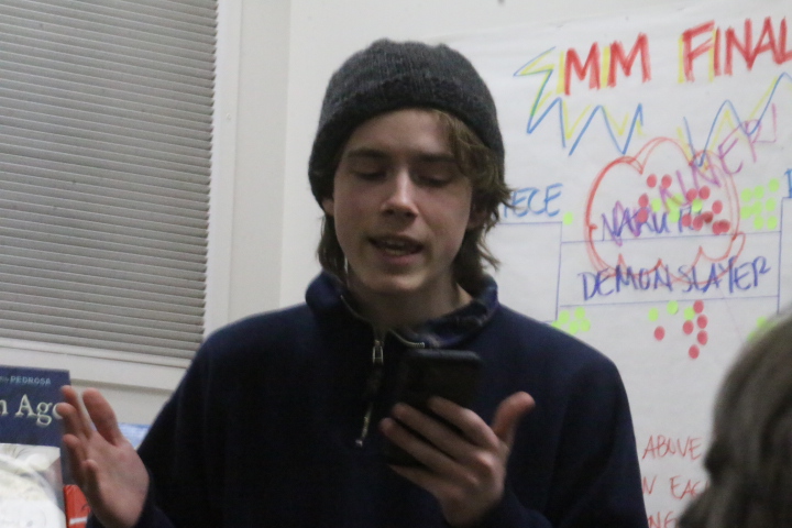 Elijah Hoch reads a poem at poetry reading on Thursday the 13th