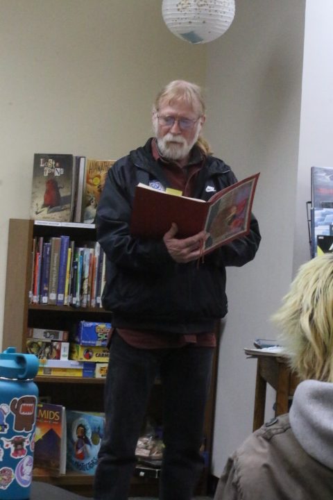 Patrick Huggins reads a poem at poetry reading on Thursday the 13th