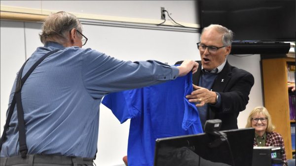 Rick Reed giving Governor Jay Inslee a All cool cubs are reading t-shirt. Inslee made a visit to Sedro-Woolley High School on February 2 to visit his friend Reed. Both Reed and Inslee were on the winning team for the state basketball championship in 1969.