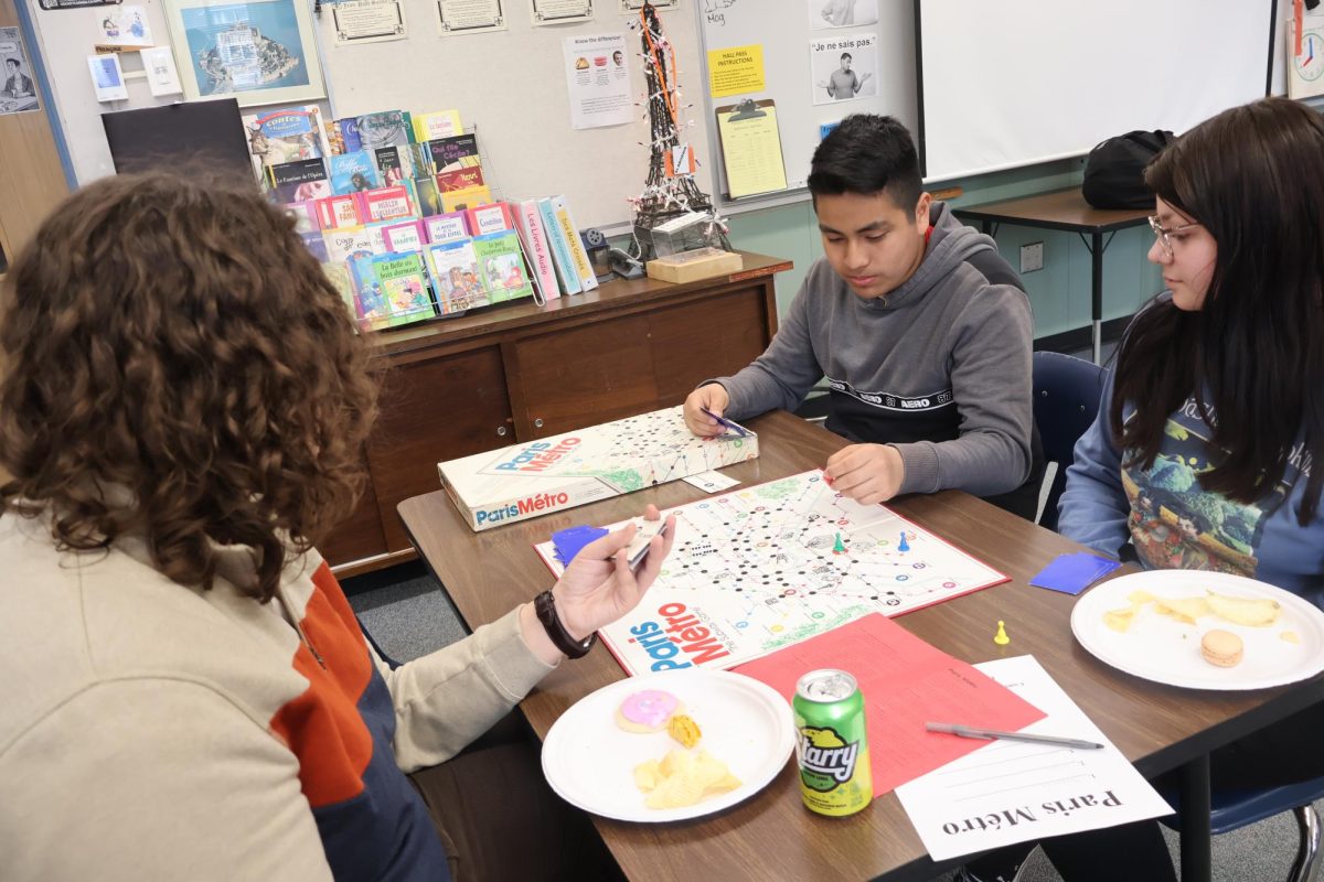 Students Joel Chavez, Jonah Hoch, and Mackenzie Poppe play French board game Paris Metro on March 29, during a French Club board game party.