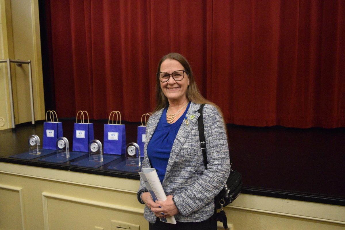Barb Morgan next to her Community Recognition award on February 26 in the SWHS Auditorium. 
